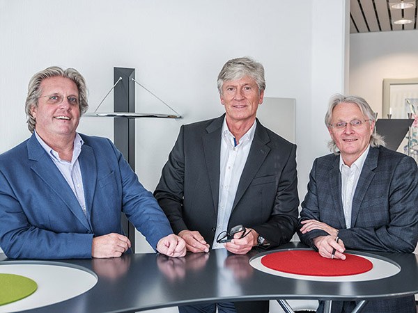 Die Anwälte Peters, Schoenlein und Peters stehen um einen  Tisch